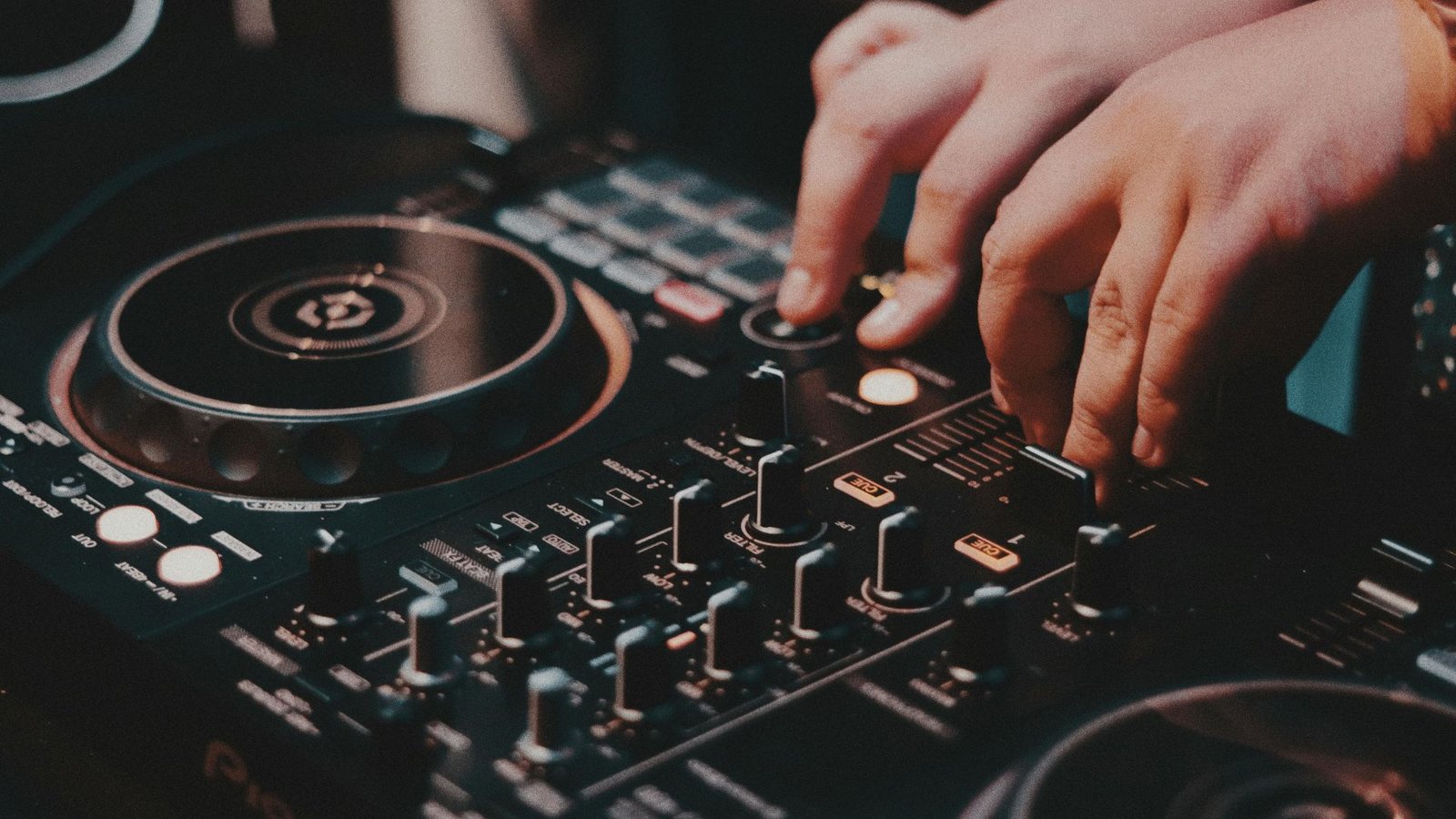 DJ performing at a vibrant event with colorful lighting