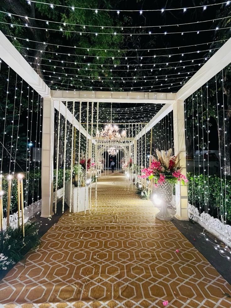 White draped entrance with string lights at night